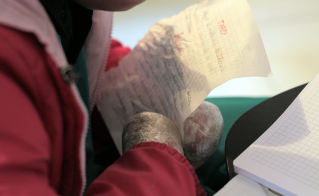 EB hands covered in saran wrap holding homework